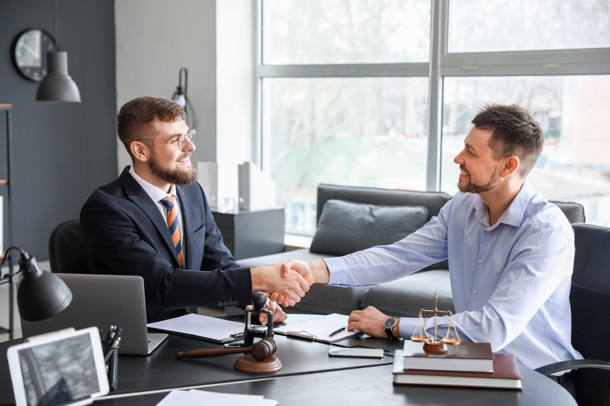 Male lawyer with client shaking hands in office Persuasive Argument